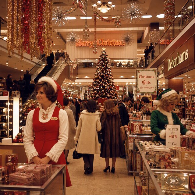 A UK department store in the 1970s at Christmas time. The lighting and decor will be very festive, with staff members dressed in festive outfits. — GPT Image 2