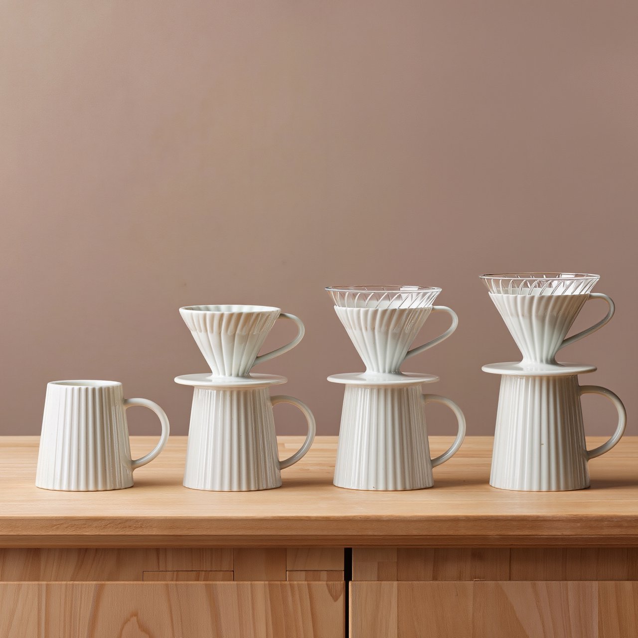 From directly overhead, an unbranded pour-over coffee set with ribbed porcelain and clear borosilicate components arranged in sequence on pale oak; warm taupe background, broad diffused softbox light and gentle side fill shape this commercial product image, no lettering. — Kling v3