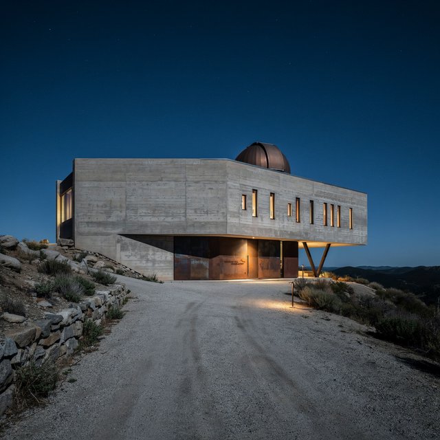 A hilltop observatory in spare contemporary architecture glows against the midnight sky, its pale concrete walls, bronze panels, and narrow windows lit from within; viewed from the access road, crisp edges and credible structural supports. — Ideogram v4