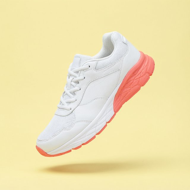 A white running sneaker with a coral sole floating at a slight angle over a pastel yellow background, studio lighting, no shadow on the backdrop. — Qwen Image 3.0 Pro