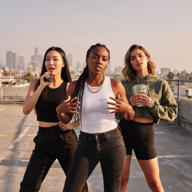 Realistic adult Korean, Black, and mixed-race female rappers filming a music video, all wearing fitted clothes. The music video is about how they are making money and are set to rule, with a really cool, laid-back vibe, shown from many angles. — Ideogram v4.5