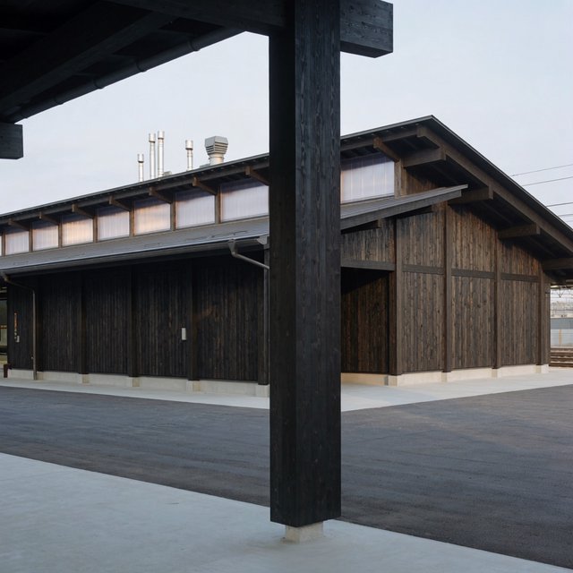Contemporary Japanese timber train station, charred cedar cladding, pale concrete platform, broad pitched roof with exposed beams and translucent clerestories, cool morning light, viewed obliquely from the quiet approach plaza, precise straight lines and plausible structure. — Krea 2 Medium