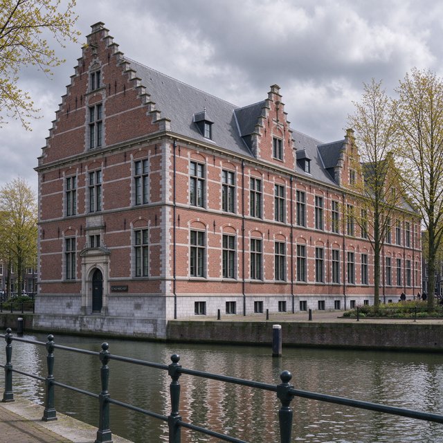 Exterior of a Dutch Renaissance canal-side archive, with warm red brick, pale stone bands, stepped gables, and tall sash windows; soft overcast light reveals the masonry, viewed from the opposite quay, with convincing structure and precise architectural lines. — Seedream 5.0 Flash