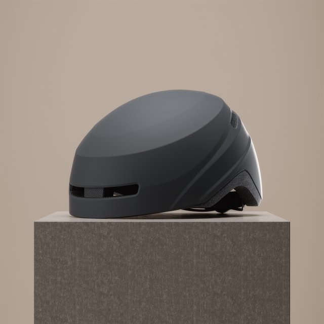 Commercial product photograph of an unbranded folding bicycle helmet made from matte charcoal polymer with soft gray padding, resting on a honed concrete plinth against a muted sand background, illuminated by a broad overhead softbox and gentle rim light. — Kling v3 Omni