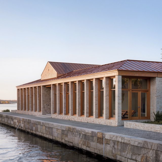A riverside public library in contemporary Nordic brick architecture combines pale buff brick, oak-framed glazing, and a copper roof; cool morning light grazes its elevations, viewed from across the promenade, with straight lines and credible supports. — Model 9