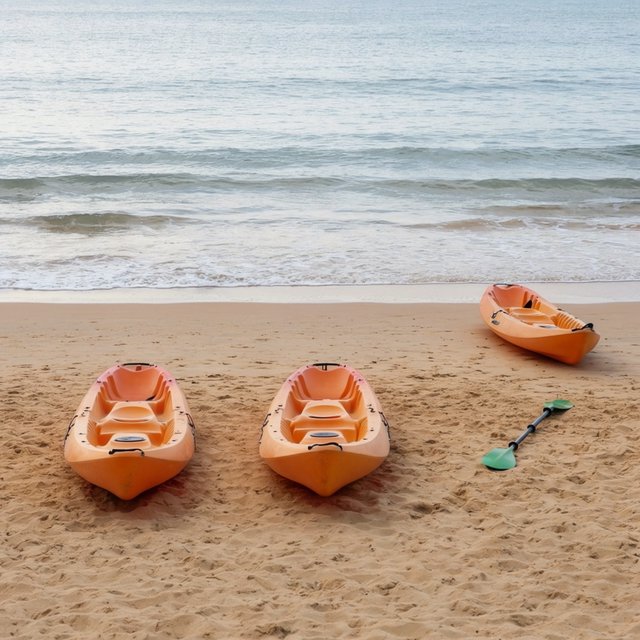 Exactly three orange kayaks rest on a sandy shore: two side by side in the foreground and one behind them near the water. A green paddle lies to the right of the kayaks, nothing else. — Krea 2 Large