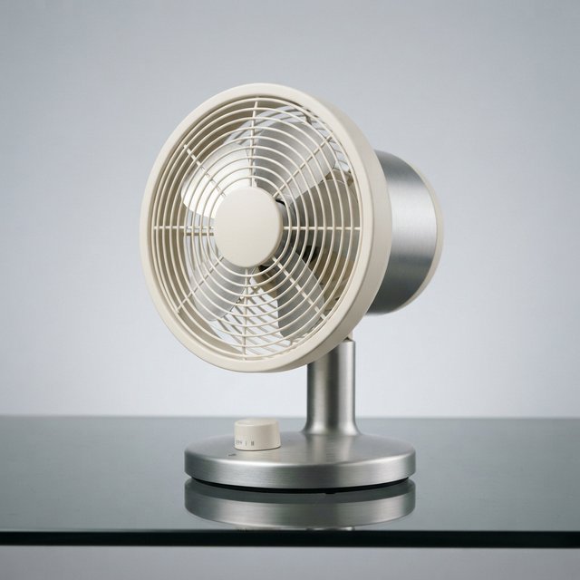 Commercial product photograph of an unbranded desktop fan made from brushed aluminum and matte ivory polymer, resting on a smoked glass surface against a pale gray background, illuminated by broad diffused studio light and a soft rear rim light. — Nano Banana 2 Lite