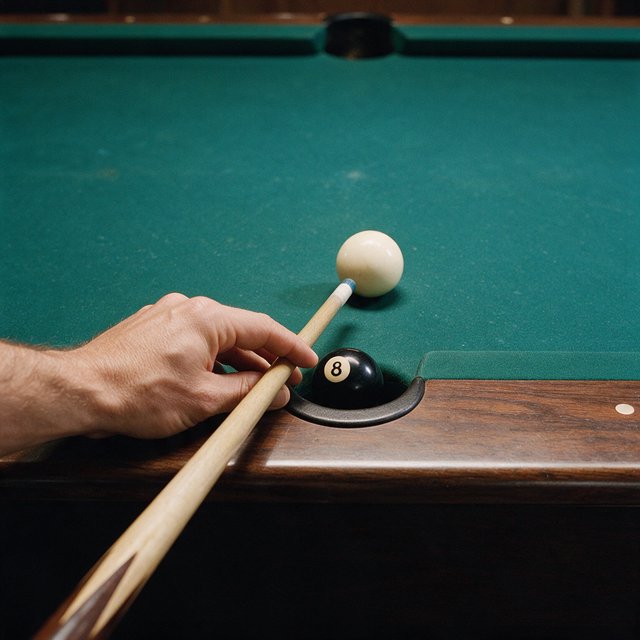 First-person perspective of an adult pool player’s left hand holding the cue, aiming the white cue ball at the black 8-ball and intending to pocket it in the center pocket. — Seedream 5.0 Pro