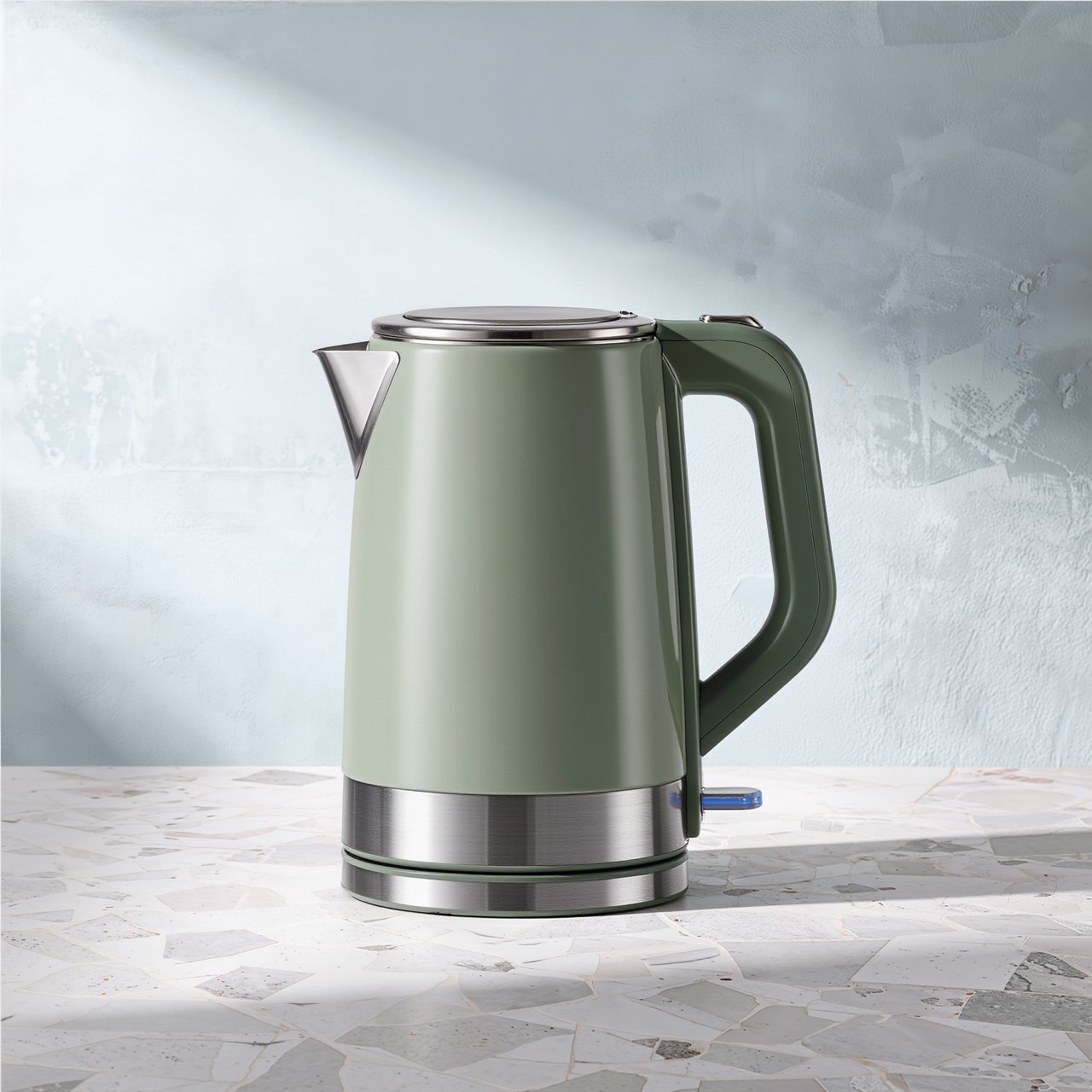 Commercial product photograph of an unbranded electric kettle made from matte sage ceramic and brushed stainless steel, resting on a white terrazzo surface against a pale blue background, with soft window light from the left and a delicate grounding shadow. — Kling v3