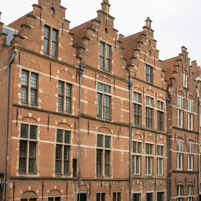 Exterior of a Dutch Renaissance canal-side archive, with warm red brick, pale stone bands, stepped gables, and tall sash windows; soft overcast light reveals the masonry, viewed from the opposite quay, with convincing structure and precise architectural lines. — Qwen Image 3.0