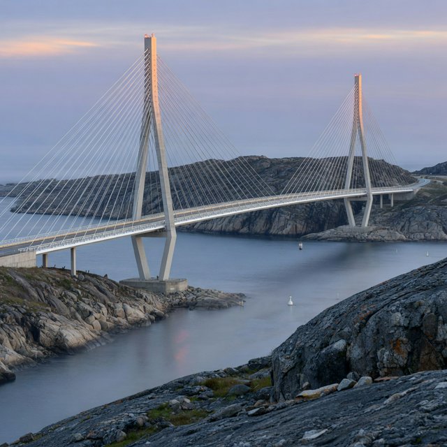 Across a sheltered coastal inlet, a contemporary high-tech cable-stayed bridge spans between granite shores, its slender steel pylons and pale concrete deck catching cool sunrise light; viewed from a rocky bank, straight lines and credible engineering define the scene. — Grok Imagine Image Quality