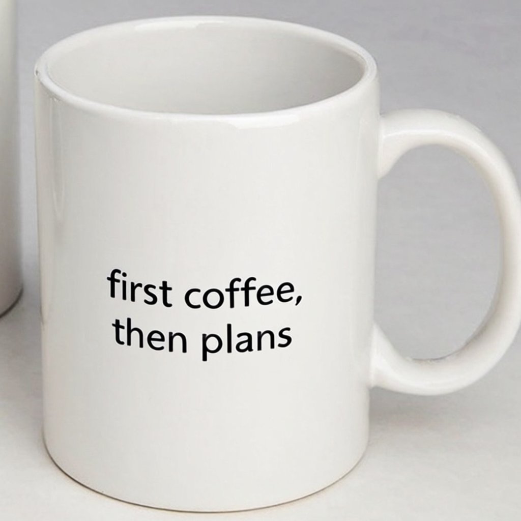 A white ceramic mug on a desk with the words "first coffee, then plans" printed in black lowercase sans-serif. — Krea 2 Large