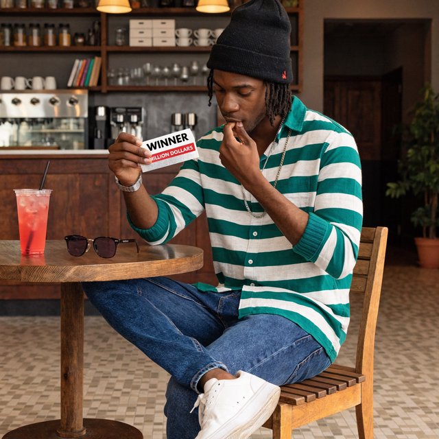 A realistic scene of a random adult person, either Black, white, or Asian, scratching a scratch ticket and discovering that they have won one million dollars. — Recraft v4 Pro