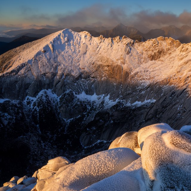Wind combs a high granite ridge above a glacial cirque at sunrise, beneath clearing snow squalls; granular rime crusts foreground boulders while successive peaks dissolve into blue cloud shadow. — Krea 2 Large