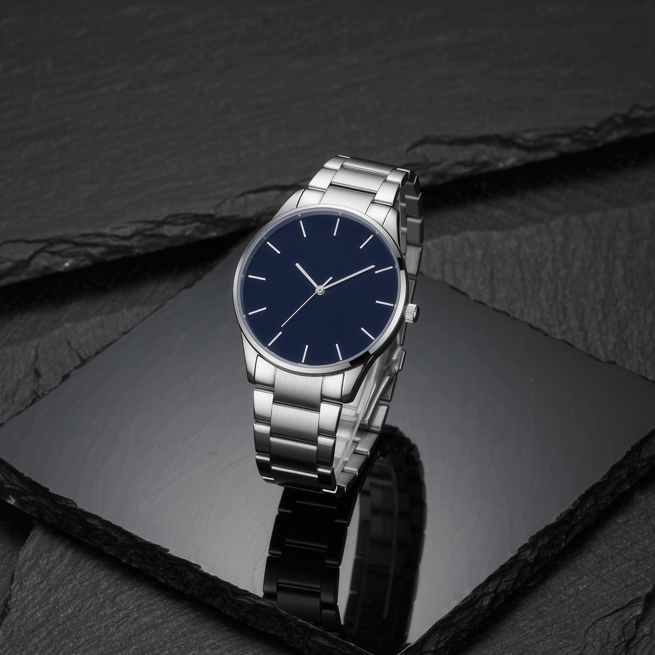 Product shot of a minimalist steel wristwatch with a navy dial on dark slate, single softbox from the upper left, subtle reflection. — Kling v3 Omni