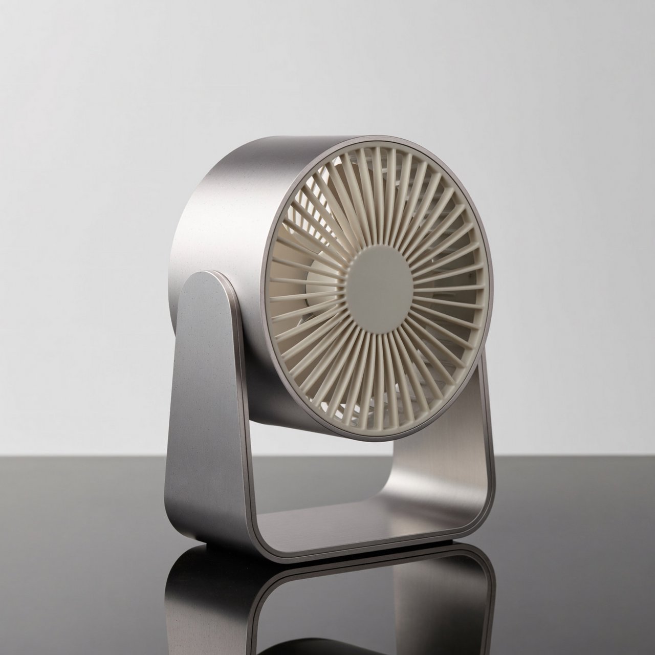 Commercial product photograph of an unbranded desktop fan made from brushed aluminum and matte ivory polymer, resting on a smoked glass surface against a pale gray background, illuminated by broad diffused studio light and a soft rear rim light. — ImagineArt 2