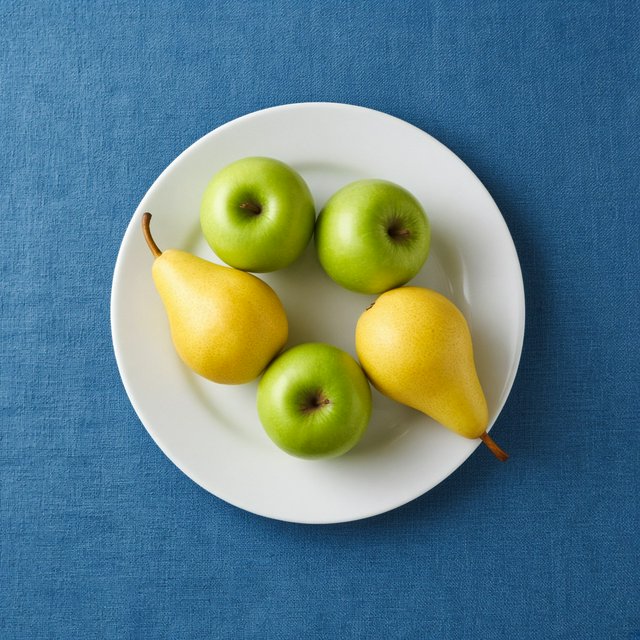 Exactly three green apples and two yellow pears on a white plate, the plate on a blue tablecloth, nothing else on the table. — Grok Imagine Image 2