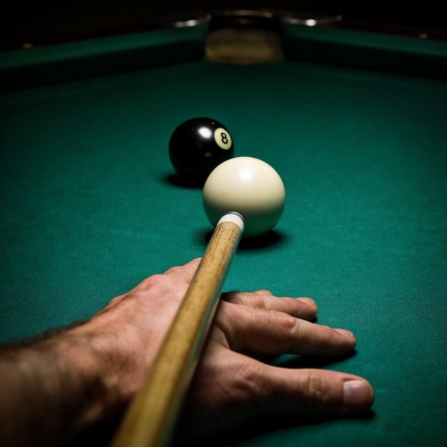 First-person perspective of an adult pool player’s left hand holding the cue, aiming the white cue ball at the black 8-ball and intending to pocket it in the center pocket. — Krea 2 Large