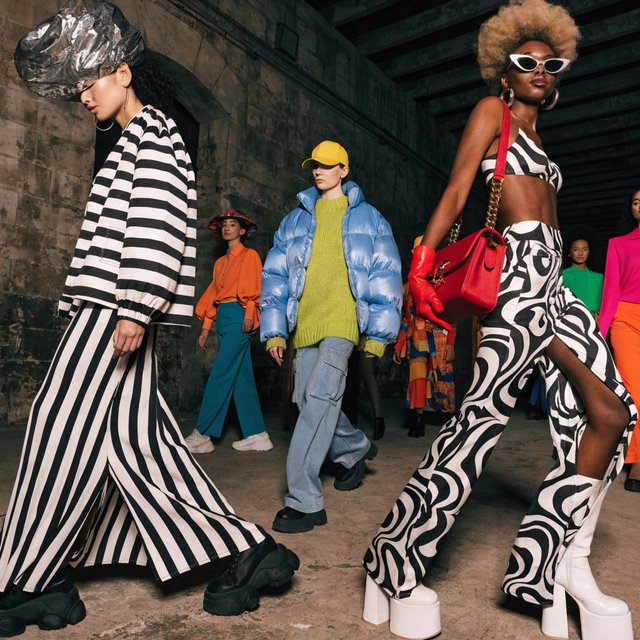 Adult female fashion models on the runway. There are models of all races: white, Black, Asian, Mexican, Indian, mixed race, etc. The vibe is cool and fierce. Many angles. — Recraft v4