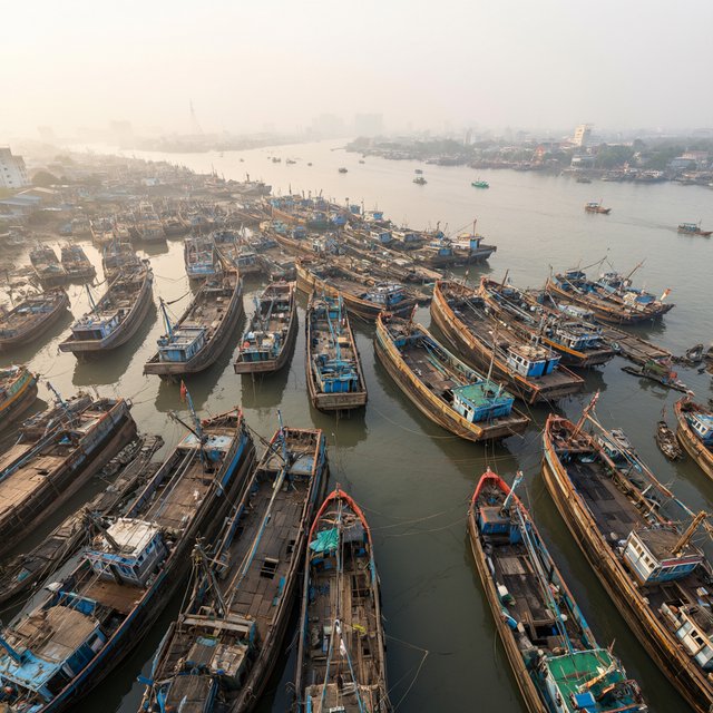 A floating market city built on the hulls of giant upturned ships, rope bridges, morning haze, wide establishing shot. — Qwen Image 3.0 Pro