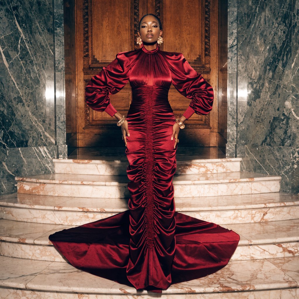 An adult woman in a floor-length red satin evening gown on a marble staircase, soft key light, confident pose, magazine cover style. — Recraft v4