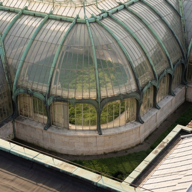 From a nearby rooftop, an Art Nouveau conservatory curves around a planted courtyard, its green copper ribs, clear glass, and pale stone base catching hazy morning light; orderly rooflines and believable supports show from above. — Krea 2 Medium