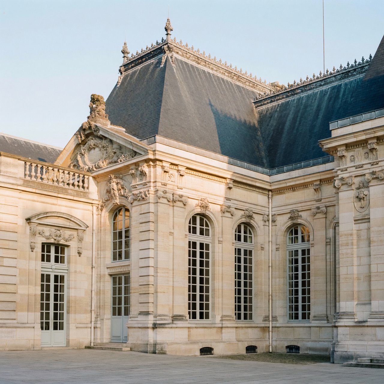 Exterior of a French Second Empire town hall with pale limestone, a dark mansard roof, copper cresting, and tall arched windows; clear spring light falls across the entrance terrace, viewed from the quiet street corner, precise lines and believable construction. — ImagineArt 2