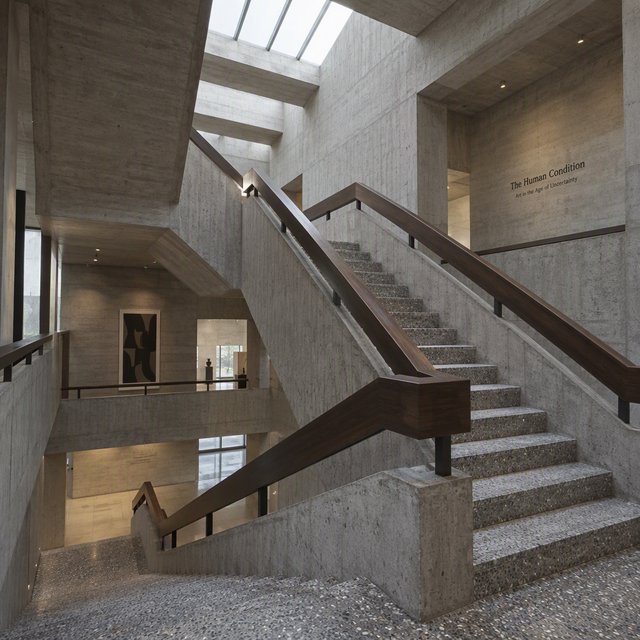 At the heart of a restrained Brutalist museum, a folded concrete stair rises beside smoked-oak handrails and terrazzo landings; skylight washes the treads, seen from the lower landing, with aligned flights and believable supports. — GPT Image 2.5 Sunburst