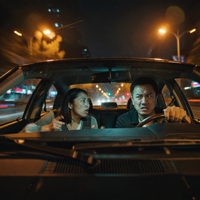 Frontal cinematic shot through the windshield of a car driving at night. A 35-year-old Chinese man is in the driver’s seat, gripping the steering wheel and arguing back in visible frustration. Beside him, a 30-year-old Chinese woman in the front passenger seat is nagging him animatedly, gesturing as she speaks. Both are clearly engaged in a tense argument. Nighttime city lights and passing streetlights glow outside, with reflections across the windshield and realistic interior lighting. — ImagineArt 2
