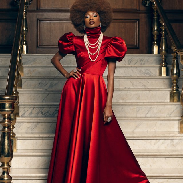 An adult woman in a floor-length red satin evening gown on a marble staircase, soft key light, confident pose, magazine cover style. — Recraft v4 Pro