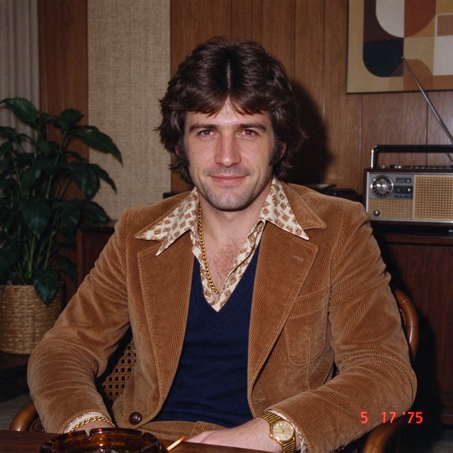 Create an image of a man in the quintessential style of 1975. Style his hair, clothing, accessories, and surroundings to reflect the distinctive look of the mid-1970s—featuring bold silhouettes, eye-catching accessories, layered details, and characteristic colors and textures. Give the image the feel of an authentic 1975 photograph, complete with analog film grain, faded colors, direct flash lighting, and a slight soft-focus effect. Add a period-accurate, red-orange date stamp in a 1970s style in one of the bottom corners. No recognizable posters. No modern objects or text. — Seedream 5.0 Flash