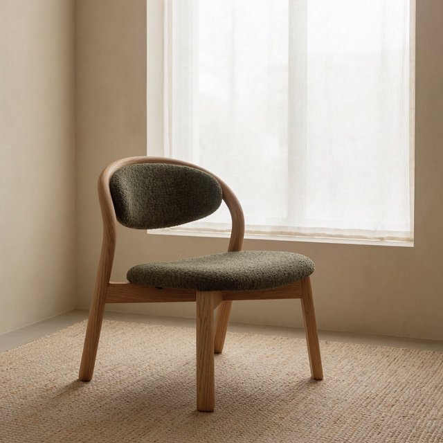 In a quiet reading-room corner, an unbranded lounge chair pairs a curved ash frame with nubby moss-green wool upholstery, set on a pale jute rug before a warm plaster wall; broad window diffusion and soft bounce shape this commercial product image, with no lettering. — Krea 2 Medium