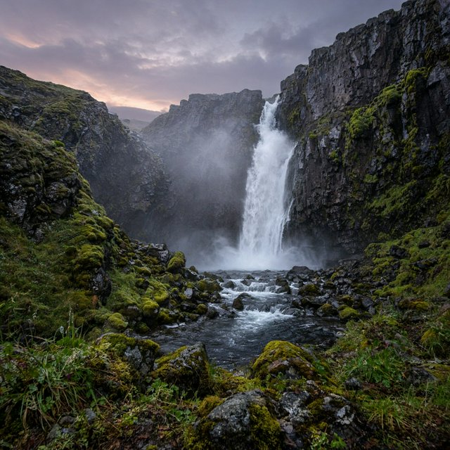After a passing squall, a waterfall drops through a narrow basalt gorge at dusk, its white plume breaking against dark ledges; rain-beaded moss and sharp foreground stones lead toward cliffs fading behind drifting spray. — Grok Imagine Image 2