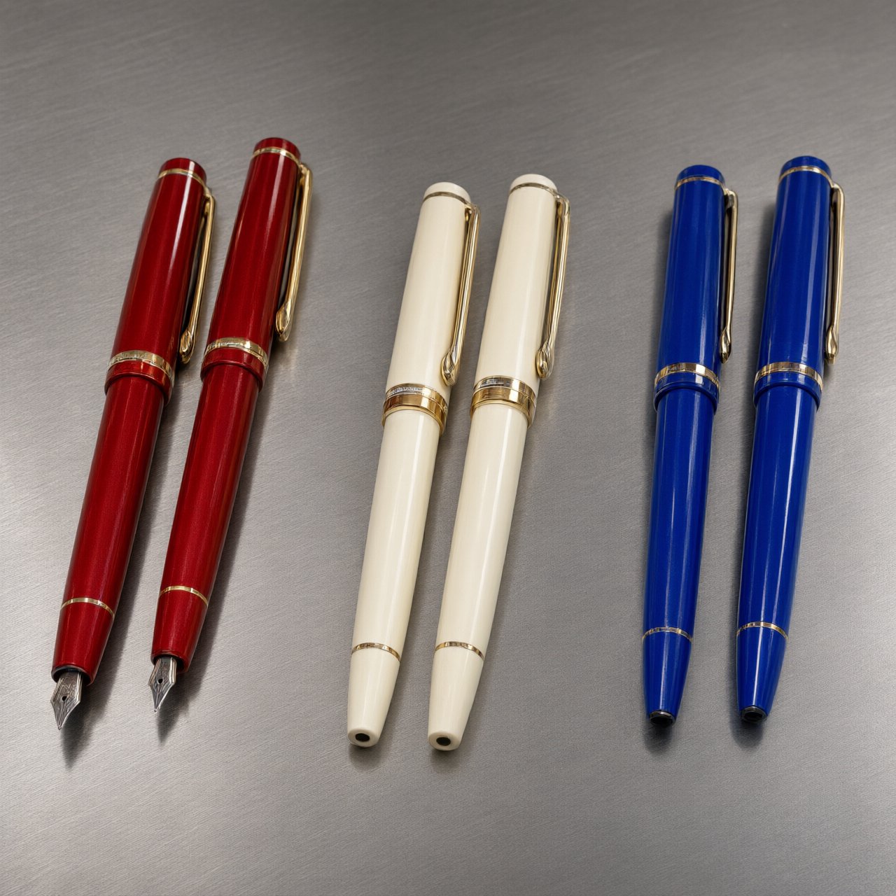 Across a brushed steel counter, exactly six fountain pens rest in three groups: two crimson pens on the left, two ivory pens in the center, and two cobalt pens on the right; nothing else. — Qwen Image 3.0