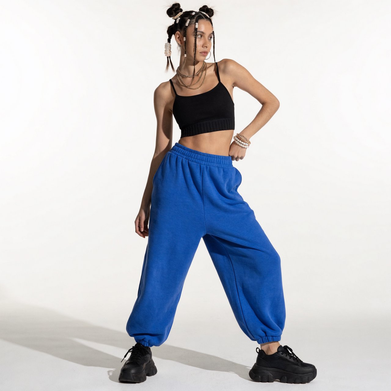 A pretty, slim woman with wide hips, wearing gym wear. Full-body image. Plain background. — Recraft v4 Pro