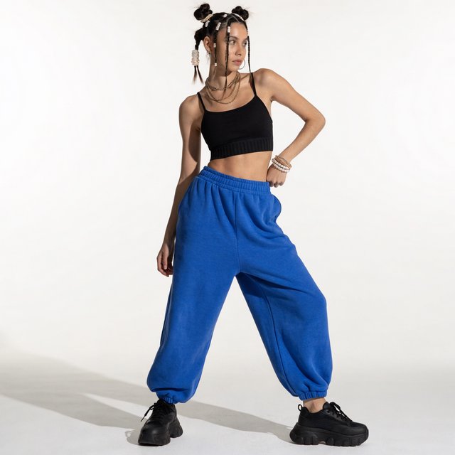 A pretty, slim woman with wide hips, wearing gym wear. Full-body image. Plain background. — Recraft v4 Pro