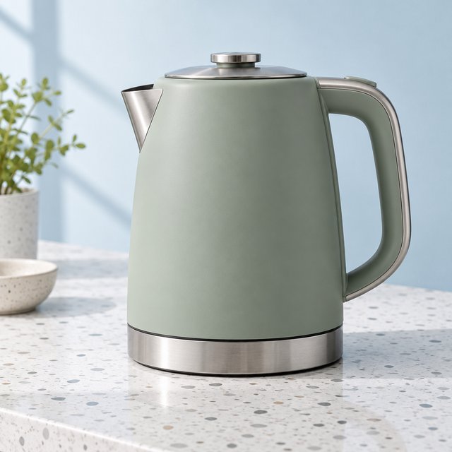 Commercial product photograph of an unbranded electric kettle made from matte sage ceramic and brushed stainless steel, resting on a white terrazzo surface against a pale blue background, with soft window light from the left and a delicate grounding shadow. — GPT Image 2.5 Sunburst