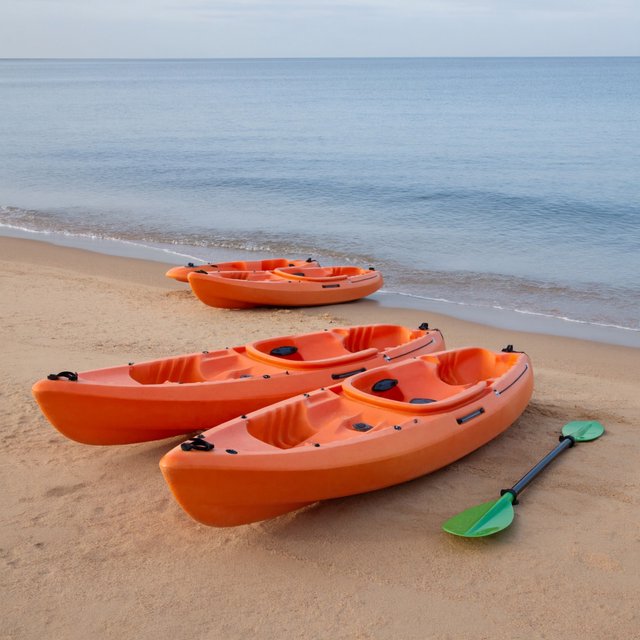 Exactly three orange kayaks rest on a sandy shore: two side by side in the foreground and one behind them near the water. A green paddle lies to the right of the kayaks, nothing else. — ImagineArt 2