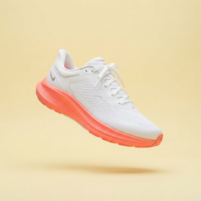 A white running sneaker with a coral sole floating at a slight angle over a pastel yellow background, studio lighting, no shadow on the backdrop. — Nano Banana 2 Lite