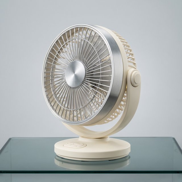 Commercial product photograph of an unbranded desktop fan made from brushed aluminum and matte ivory polymer, resting on a smoked glass surface against a pale gray background, illuminated by broad diffused studio light and a soft rear rim light. — Qwen Image 3.0 Pro