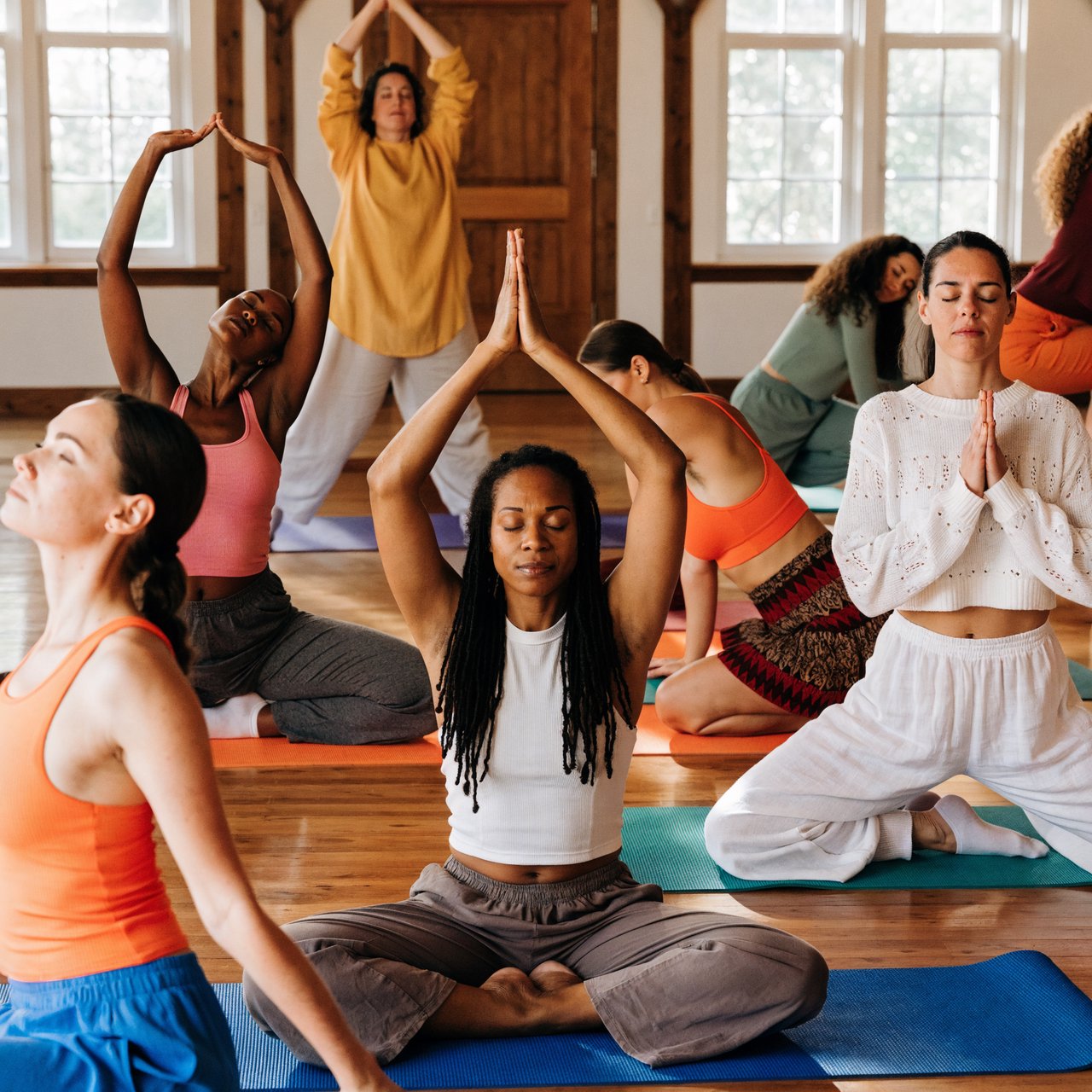 A realistic image of a group of adult women at a yoga class. Women of many races, with slim, curvy, and other body types, all wearing yoga wear, all on colorful yoga mats, all posing, with many angles and POVs. 3–6 angles. — Recraft v4 Pro