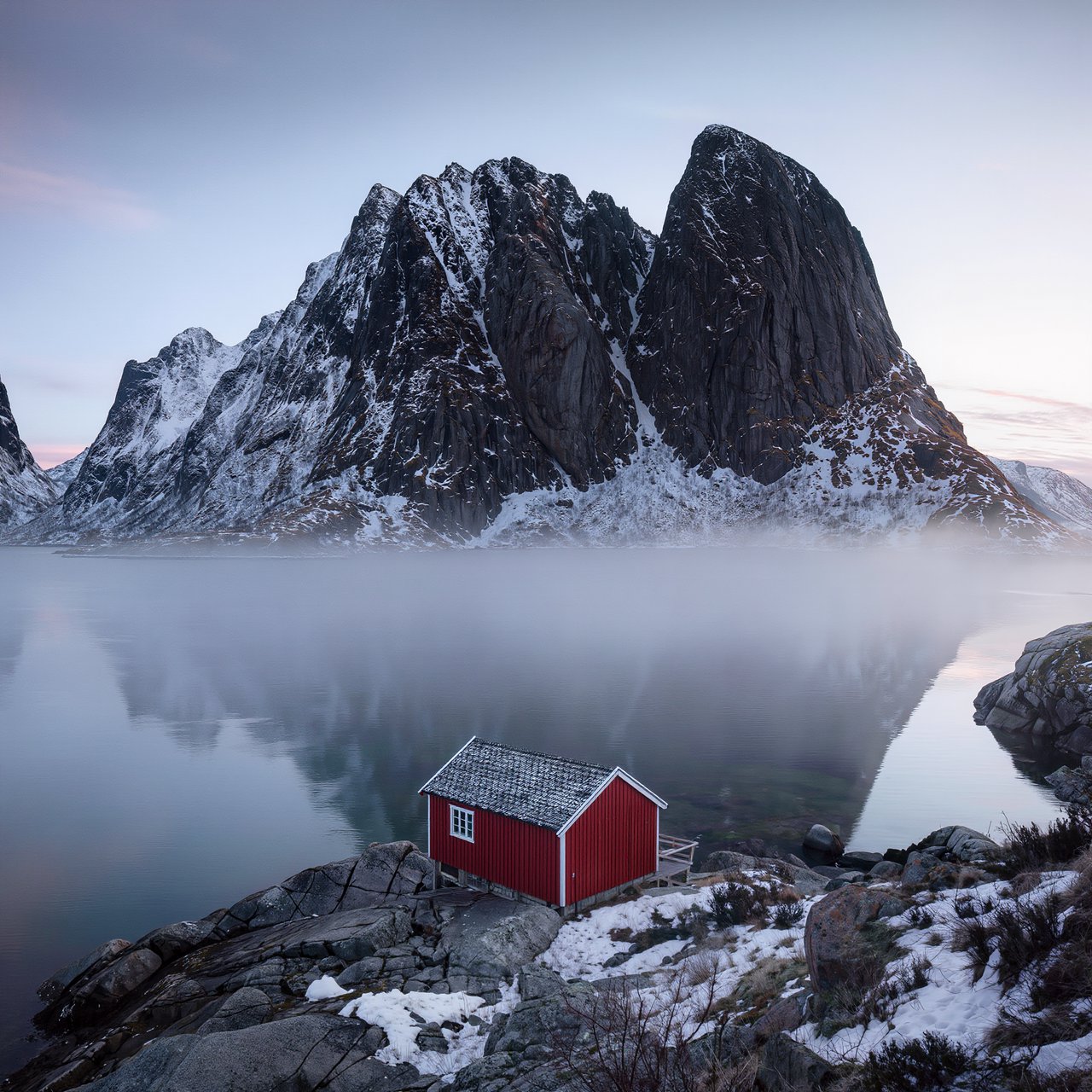A Norwegian fjord at dawn, mist over still water, a single red cabin on the shore, snow on the peaks, wide angle. — Kling v3