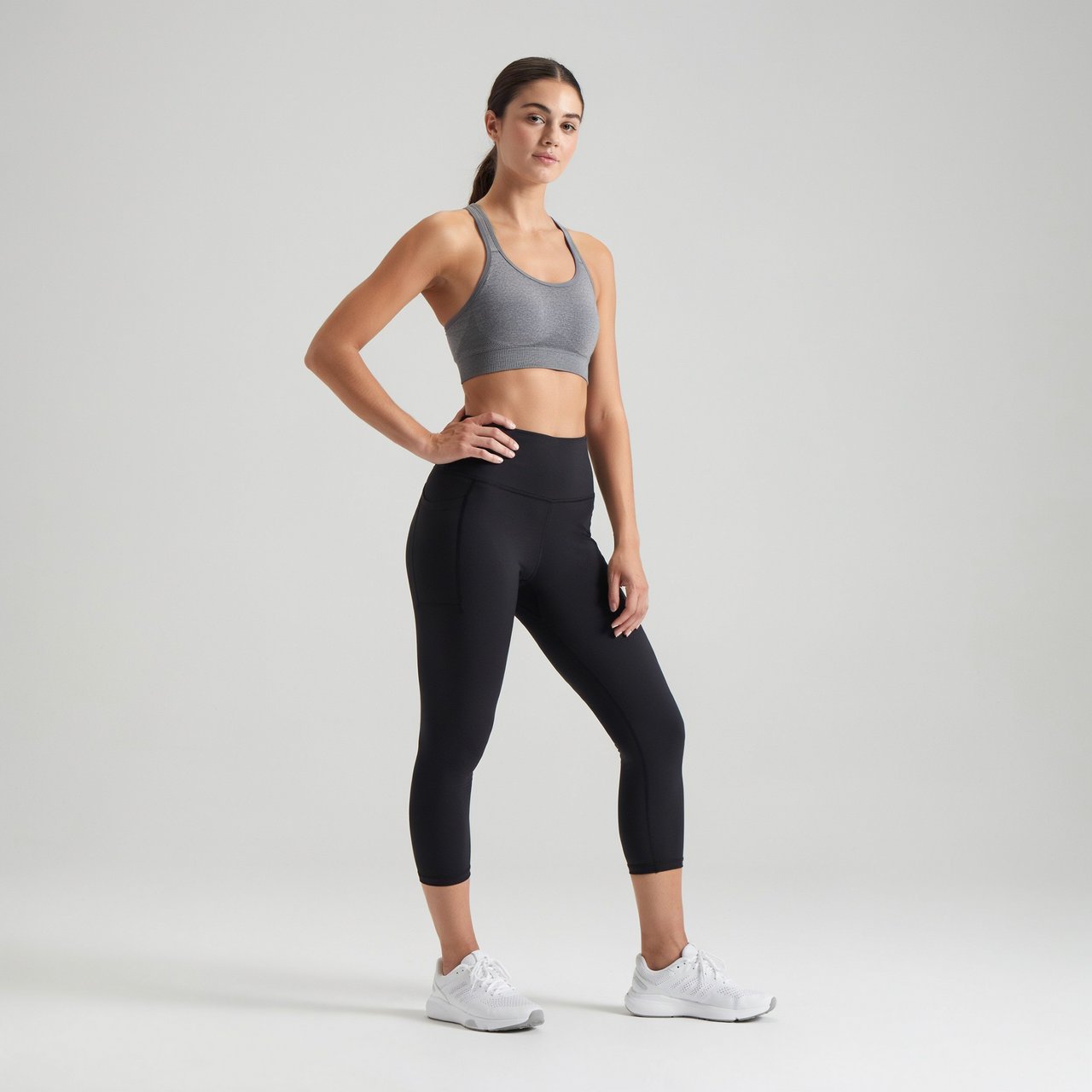 A pretty, slim woman with wide hips, wearing gym wear. Full-body image. Plain background. — Ideogram v4