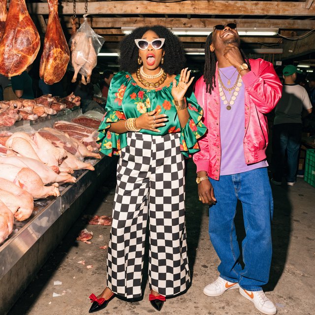 Glamorous adult couple browsing an exotic meat market. The woman has a look of pure surprise at what is on sale. The man just laughs at her reaction! The market is busy and well lit. — Recraft v4 Pro
