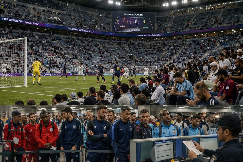 Soccer match in a large stadium with players on the field and fans in the stands during a FIFA Wo...