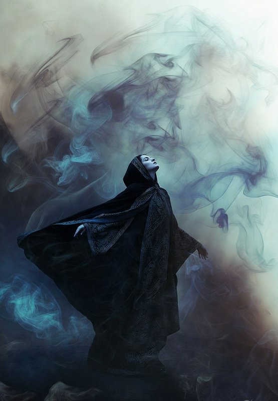 A hooded figure in a dark, patterned cloak stands amid swirling blue-gray smoke, looking upward.