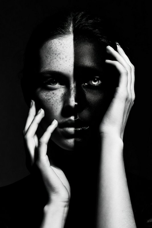 Split-face black-and-white portrait of a woman with freckled and dark halves
