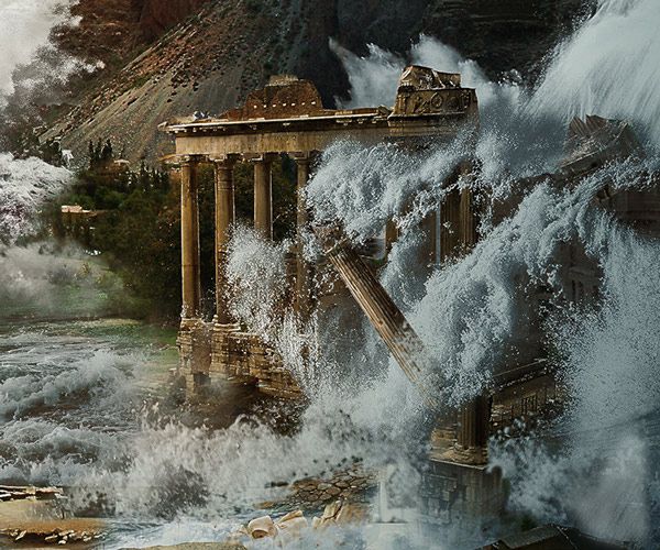 Ancient temple-style columns battered by huge waves crashing over a dam in a rocky landscape.