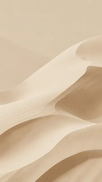 Vertical minimalist composition of soft layered sand dunes in warm beige and caramel tones