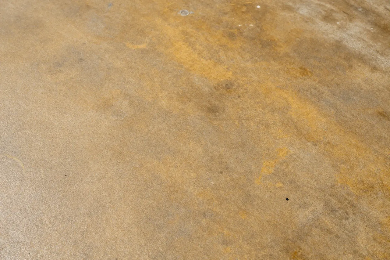 Top view flat shot of mottled amber and brown acid-stained concrete floor texture